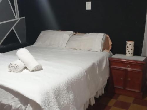 Una cama blanca con dos rollos de toallas. en Casa kukycita en San Salvador de Jujuy