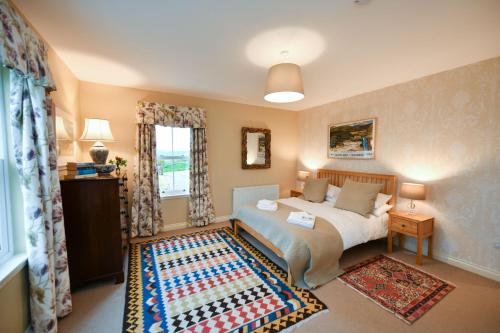 a bedroom with a bed and a window at High Clachan Farmhouse in Stranraer