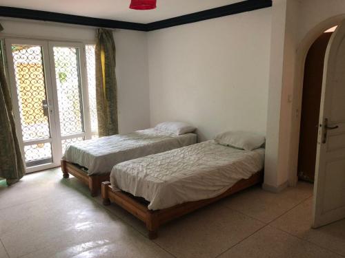 2 camas individuales en una habitación con ventana en 5 minutes de la plage en Agadir