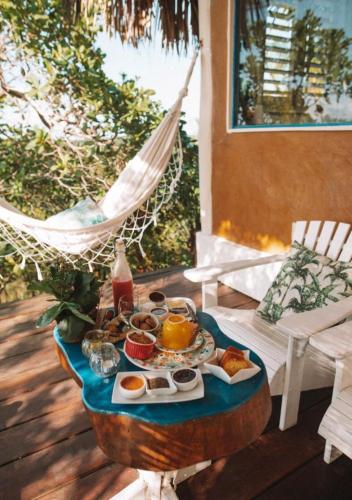 a tray of breakfast food on a table on a porch at Eco-Casa Bobô in Ilha de Boipeba