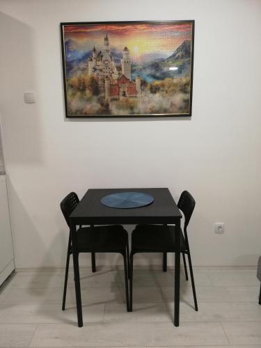 una mesa y sillas en una habitación con un cuadro en la pared en Quince, en Bor