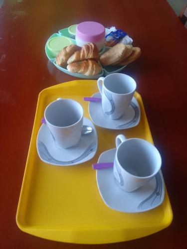 bandeja con dos tazas, platillos y bollería en EL PERSISTENTE alojamiento en Cachí