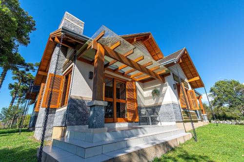 una casa construida sobre un exuberante campo verde en Rosa Casa Vivendas da Colina, en Canela