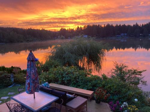 un vestido sentado en una mesa de picnic frente a un lago en Cottage Lake Bed and Breakfast en Woodinville