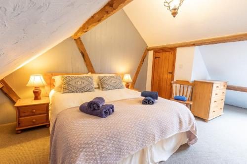 a bedroom with a bed with towels on it at West Hollowcombe Farm Cottages - full site booking in Dulverton