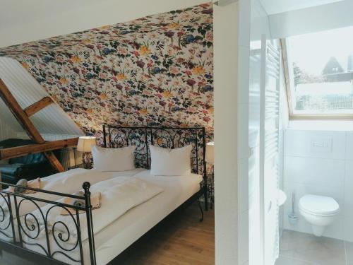 a bedroom with a bed with a floral wallpaper at Pension Pfefferstübchen in Brotterode-Trusetal