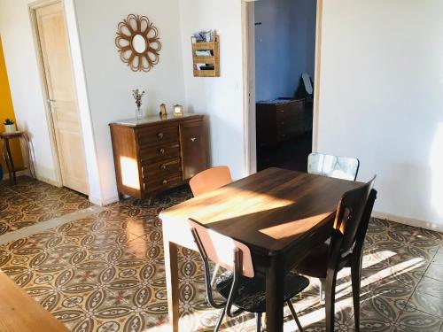a dining room with a wooden table and chairs at Gîte de la Bastide in Autignac