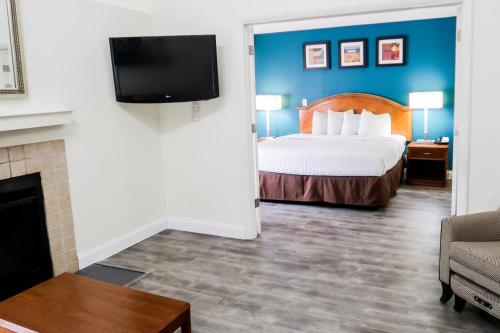 a hotel room with a bed and a tv at Tysons Corner Suites, A Baymont by Wyndham in Vienna