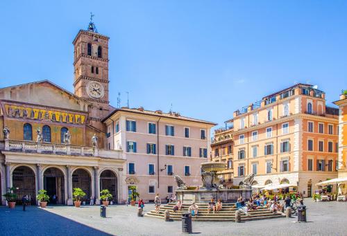 a group of buildings with a clock tower and a fountain at Rome city center in Rome