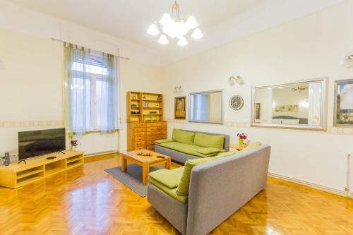 een woonkamer met een bank en een tv bij Friend of Deák Ferenc in Boedapest