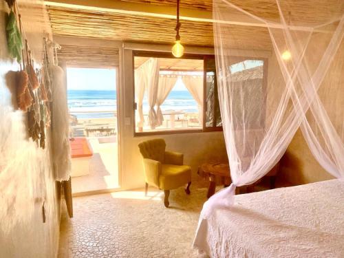 a bedroom with a bed and a view of the ocean at Casa de las Olas Surf & Beach Club in Acapulco