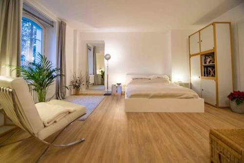 um quarto com uma cama e uma cadeira em Ground Floor in Villa in Charlottenburg Garden View em Berlim