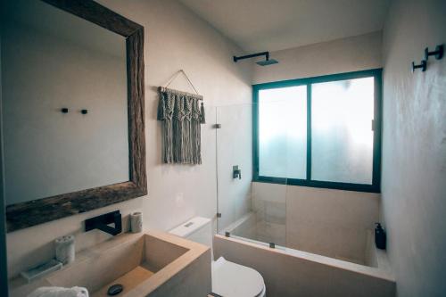 a bathroom with a tub and a toilet and a mirror at Vida Jungle Apart 7 with special fee to access Hotel Bardo in Tulum