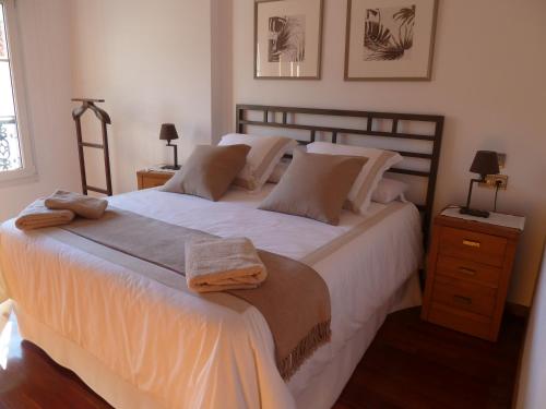 een slaapkamer met een groot bed met witte lakens en kussens bij Las Palmeras in Caldas de Reis