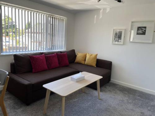 ein Wohnzimmer mit einer schwarzen Couch und einem Tisch in der Unterkunft Paradigm House, Modern 2-Bedroom Duplex Apartment 2, Free Parking, Oxford in Oxford