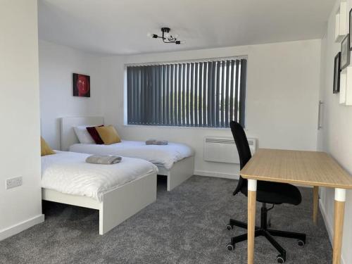 ein Zimmer mit zwei Betten und einem Schreibtisch und einem Tisch in der Unterkunft Paradigm House, Modern 2-Bedroom Duplex Apartment 2, Free Parking, Oxford in Oxford