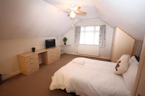een slaapkamer met een wit bed en een raam bij Oaks House in Hanworth