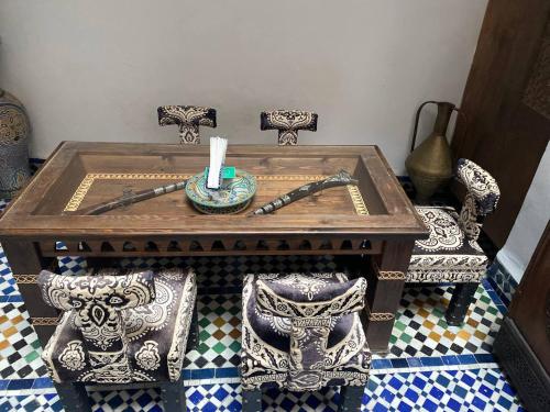 une table avec deux chaises et une bougie dessus dans l'établissement Dar Labchara, à Fès