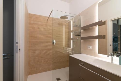 y baño con ducha, lavabo y espejo. en Vittoria Suite, con Jacuzzi - by Host4U, en Pavia
