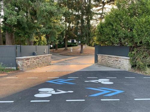 a parking lot with blue writing on the road at Maison paisible Rennes sud avec jaccuzzi sur réservation in Noyal-Châtillon-sur-Seich