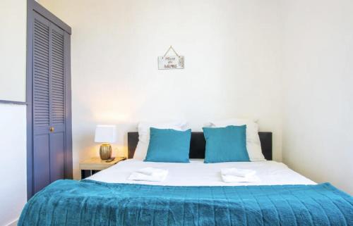um quarto com uma cama com lençóis azuis e brancos em Les Logis Poitevin - Maisons - Terrasses - Détente em Poitiers