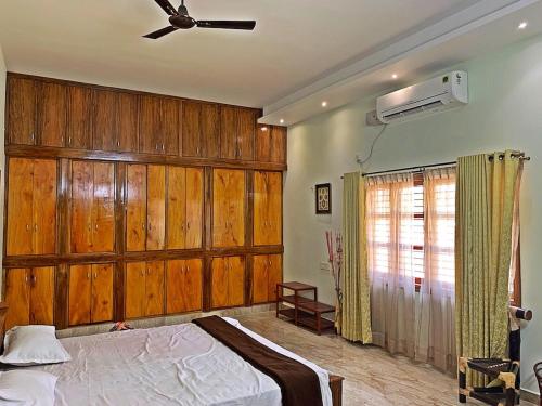 a bedroom with a bed with wooden walls and a ceiling at Monappa Estate - Top Rated - Luxury Villa in Udupi