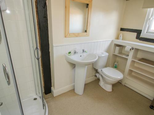 a bathroom with a sink and a toilet and a mirror at Mill End in Nantwich
