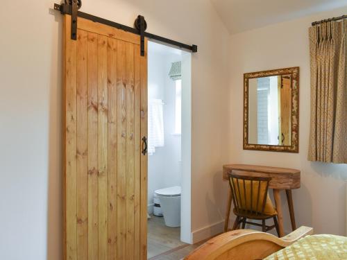 a bathroom with a wooden door leading to a toilet at South Downs Lodge in Droxford