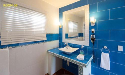 a blue bathroom with a sink and a mirror at HOTEL CASA AMARILLA et RESTAURANT in Punta Chame