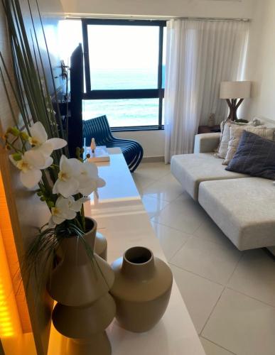 a living room with a couch and a table with flowers at ONDINA SSA in Salvador