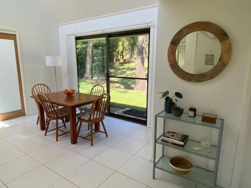 a dining room with a table and chairs and a mirror at Bawley Point accommodation in Bawley Point