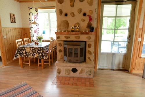ein Wohnzimmer mit einem Kamin mit einem Tisch und einem Esszimmer in der Unterkunft Wismens Natur & Fiske in Krogsered