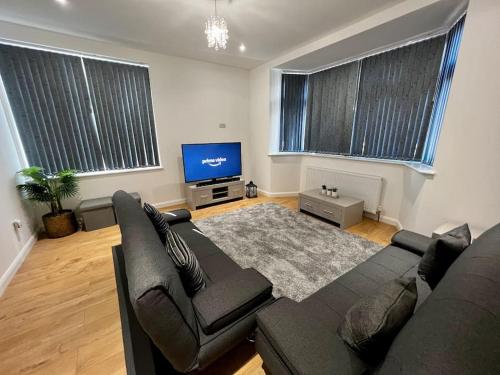 a living room with a couch and a flat screen tv at Luxury Apartment in Nuneaton in Nuneaton