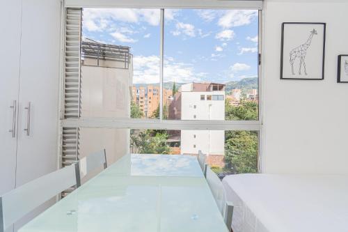 a white room with a table and a large window at Mio Loft - Vista El Poblado Free Parking Recepción 24h High Internet in Medellín