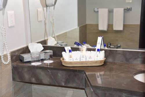 a bathroom counter with a basket of toiletries and a mirror at Hotel Royal Reforma in Mexico City