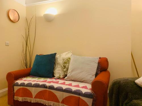 a couch with pillows on it in a room at 22A Cosy double bed town centre in Wellingborough