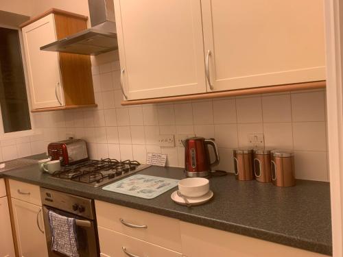 Il comprend une cuisine équipée d'une cuisinière et d'un comptoir. dans l'établissement 22A Cosy double bed town centre, à Wellingborough