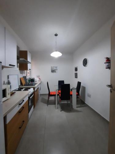 - une cuisine et une salle à manger avec une table et des chaises dans l'établissement One Bedroom apartment, à San Ġiljan