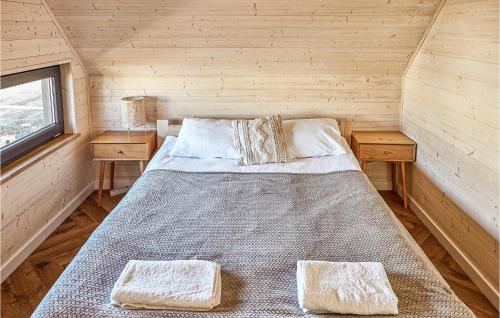 ein großes Bett in einem Holzzimmer mit zwei Tischen in der Unterkunft 2 Bedroom Cozy Home In Trzesacz in Trzęsacz