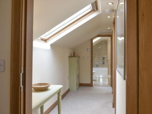 an attic hallway with a staircase with a skylight at Stallion Barn in Crosby Garrett