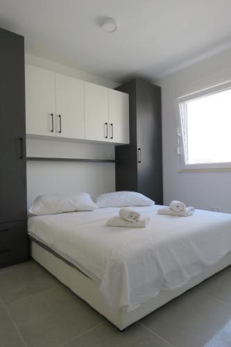 a bedroom with a large white bed with white cabinets at Villa Omazic in Trogir