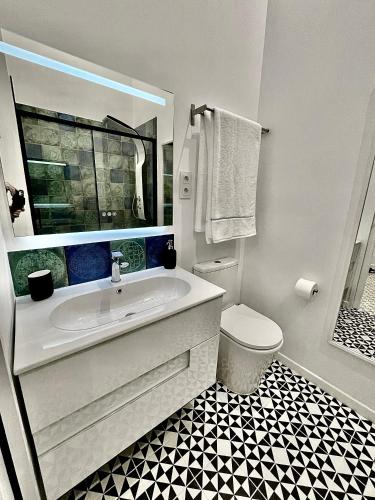 a white bathroom with a tub and a toilet at Puerta Roja 3 bedroom Luxury Apartment in Málaga
