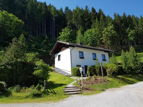 a small white house on the side of a road at Alpengasthof Draxler in Forstau