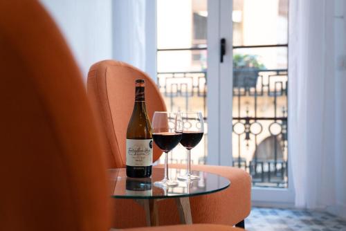 uma garrafa de vinho e dois copos numa mesa em Puerta Roja 3 bedroom Luxury Apartment em Málaga