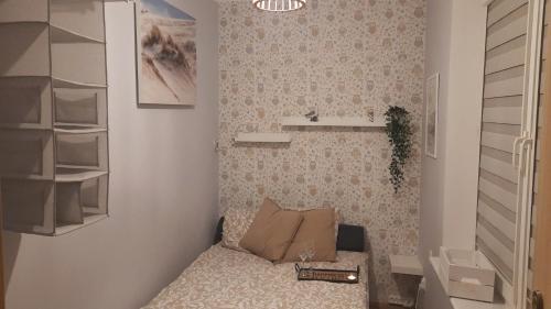 a small room with a bed and a shelf at Casa in Centro Apartments and more in Łeba