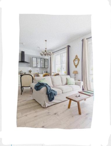 a living room with a white couch and a table at Bea Garden Home - dwie sypialnie i taras in Elblag