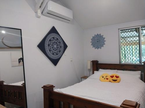 1 dormitorio con 1 cama con 2 almohadas en Oasis at Burringbar waterfront holiday 