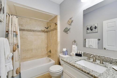 a bathroom with a tub and a sink and a toilet at Dawn 916-Hook, Wine & Sinker in Galveston