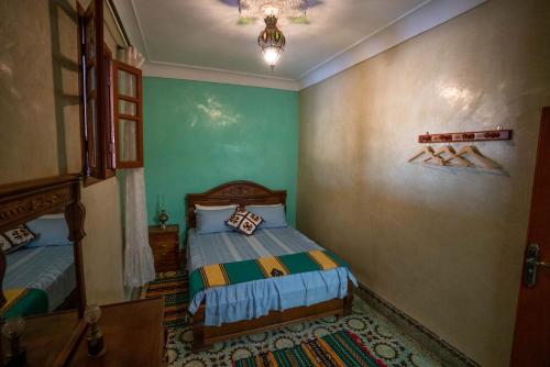 Habitación pequeña con 2 camas y lámpara de araña. en Dar El Karam Fez, en Fez