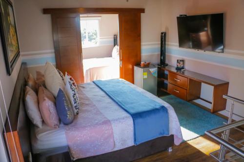 1 dormitorio con 1 cama con TV y 1 cama sidx sidx sidx sidx en Hotel Mansión Barichara en Barichara